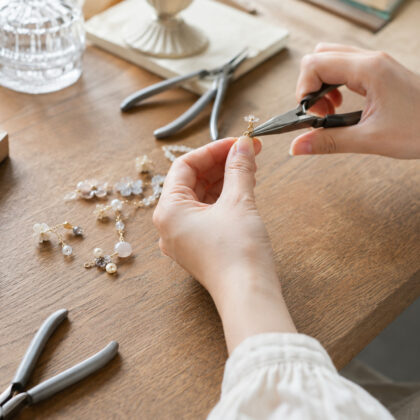 アクセサリーパーツを工具で丁寧に組み立てるハンドメイド作家の手元