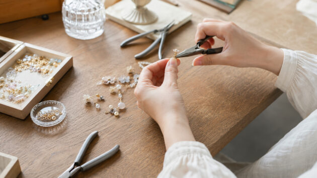 アクセサリーパーツを工具で丁寧に組み立てるハンドメイド作家の手元
