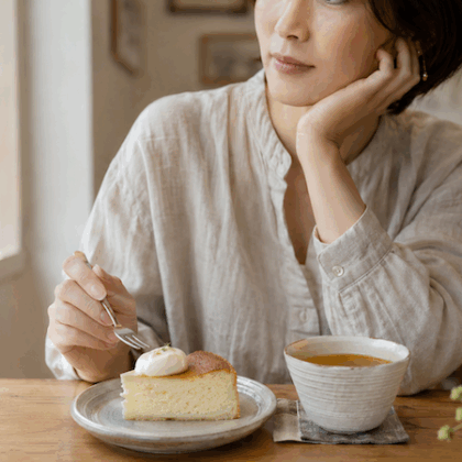 糖質を気にしながら、カフェでケーキを前に考える女性