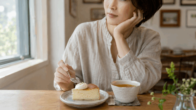 糖質を気にしながら、カフェでケーキを前に考える女性